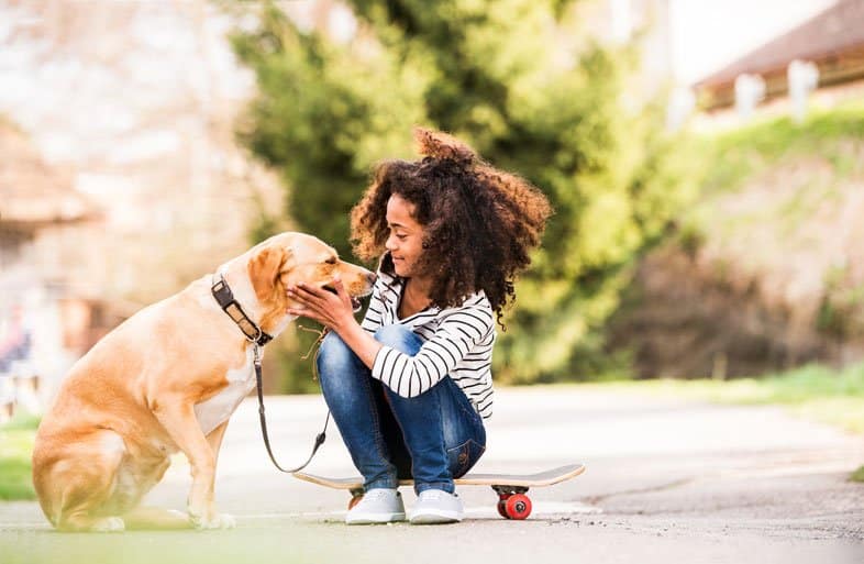 girl petting dog while on a walk